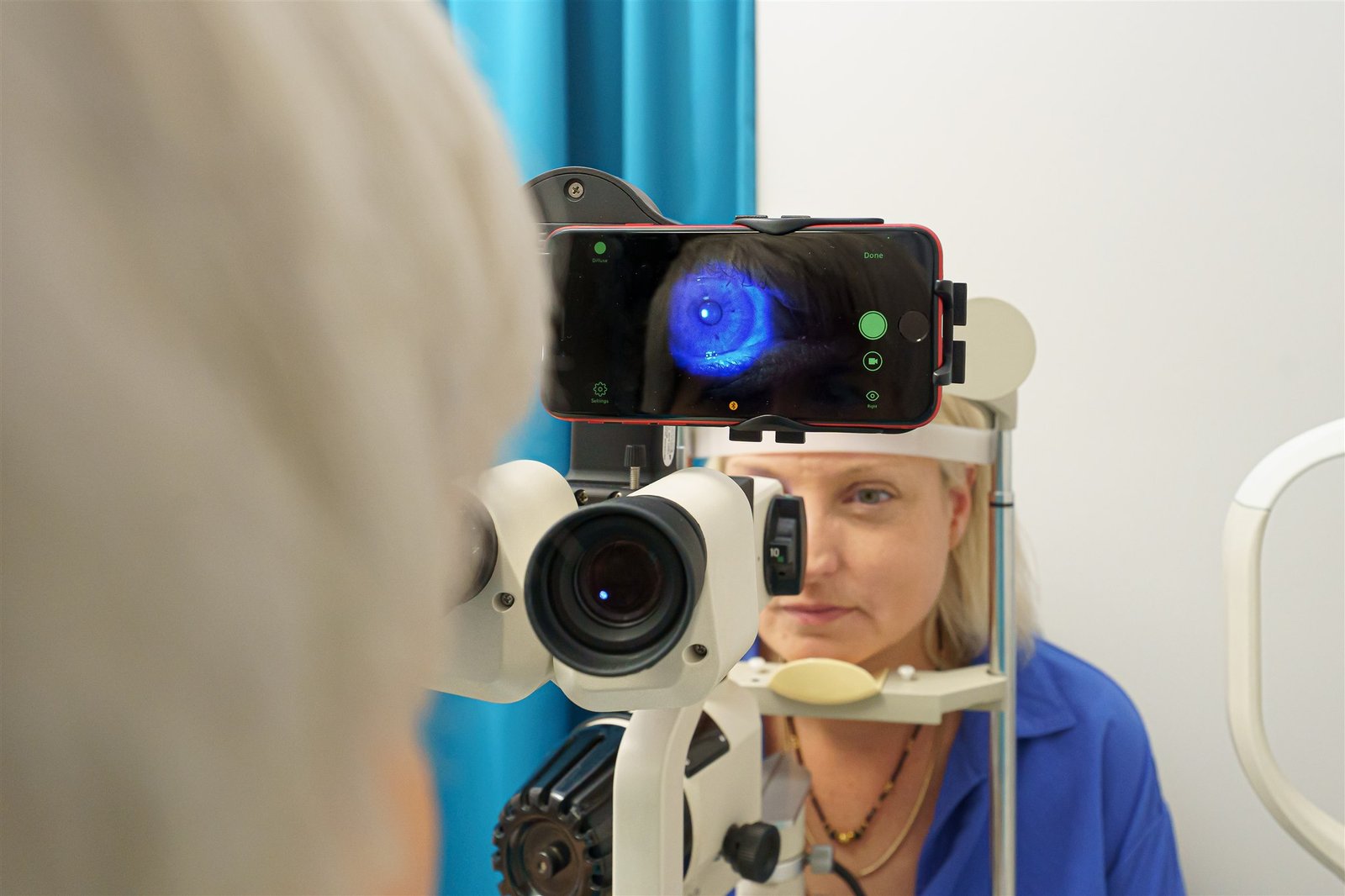 Optometrist performing a contact lens check-up with a biomicroscope.