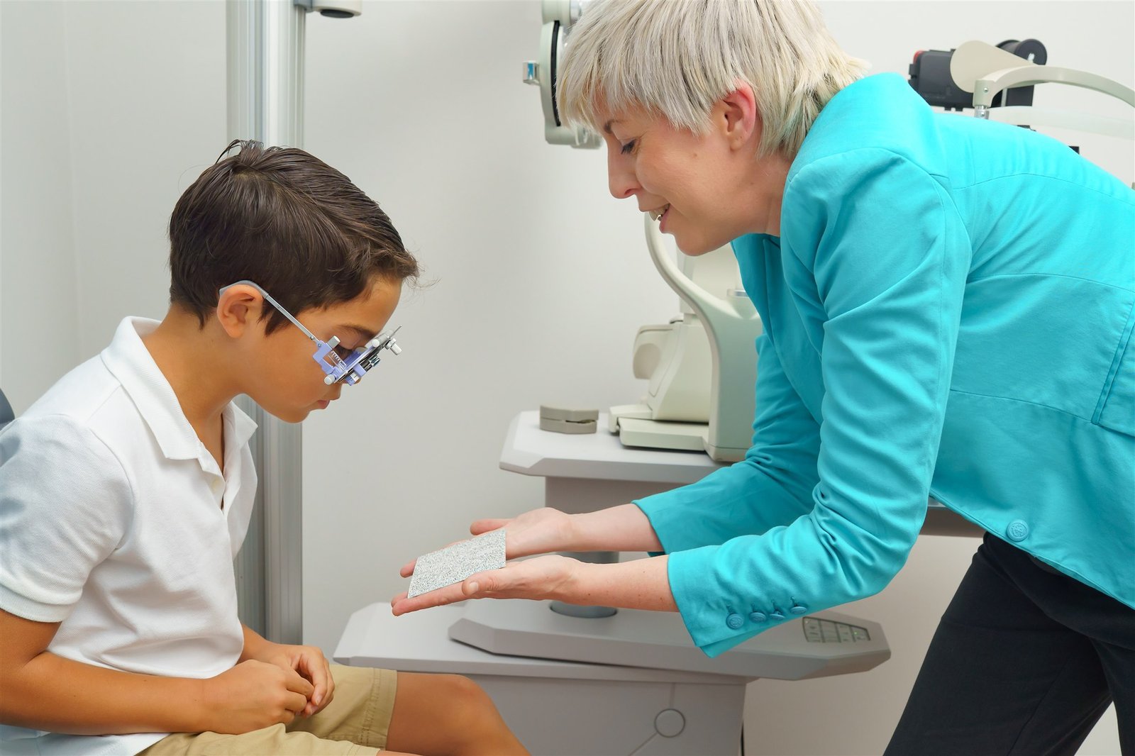 Optometrist explaining eye growth to parent and child