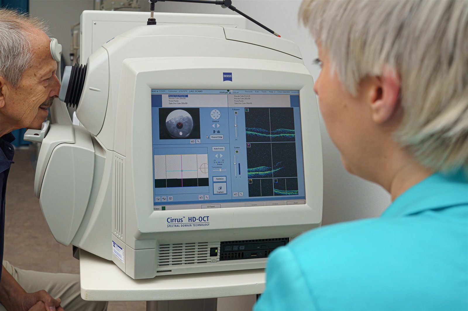 Patient sitting behind an OCT machine scanning the eye
